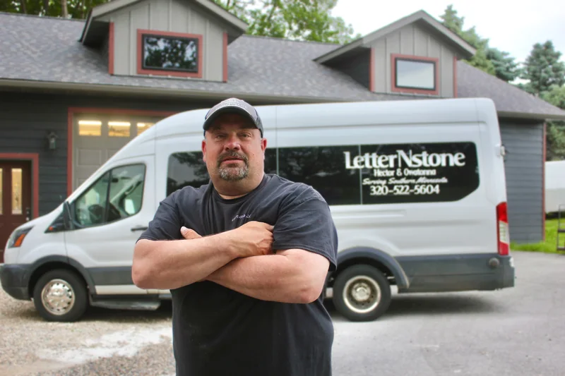 Kevin, Owner and Lead Engraver at LetterNstone, standing in front of the company van