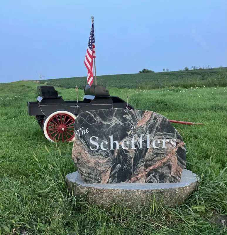 A custom engraved yard rock with a family name, set at a property entrance in Minnesota
